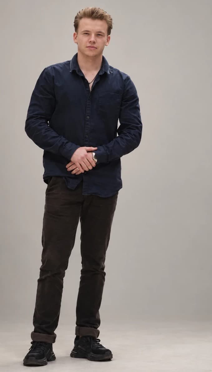 Semyon Golovanov, standing relaxed in a dark shirt.